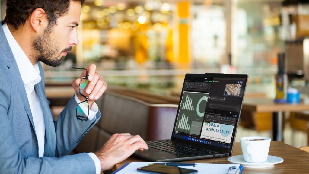 Man in a suit looking over screen at a table