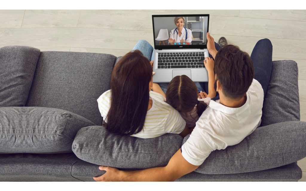 Family of three on a video call while sitting on their couch, as seen from above and behind