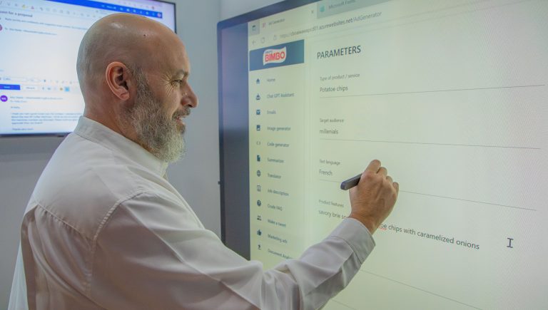 Man writing on large computer screen