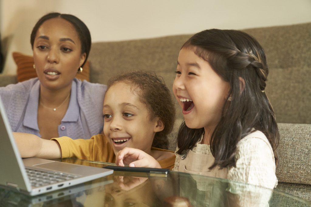 Woman and two girls enjoying what's on their laptop computer