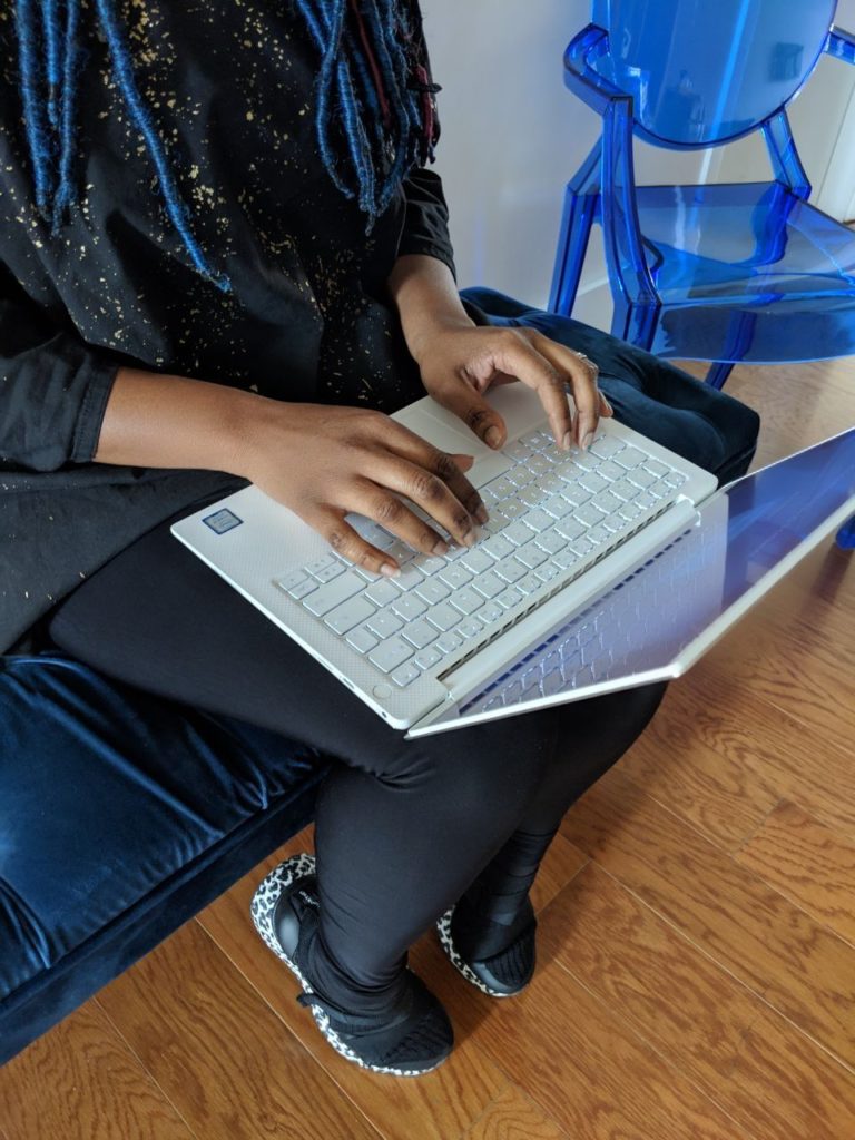 Close-up of Rakia Reynolds working on a Dell laptop, hands on the keyboard