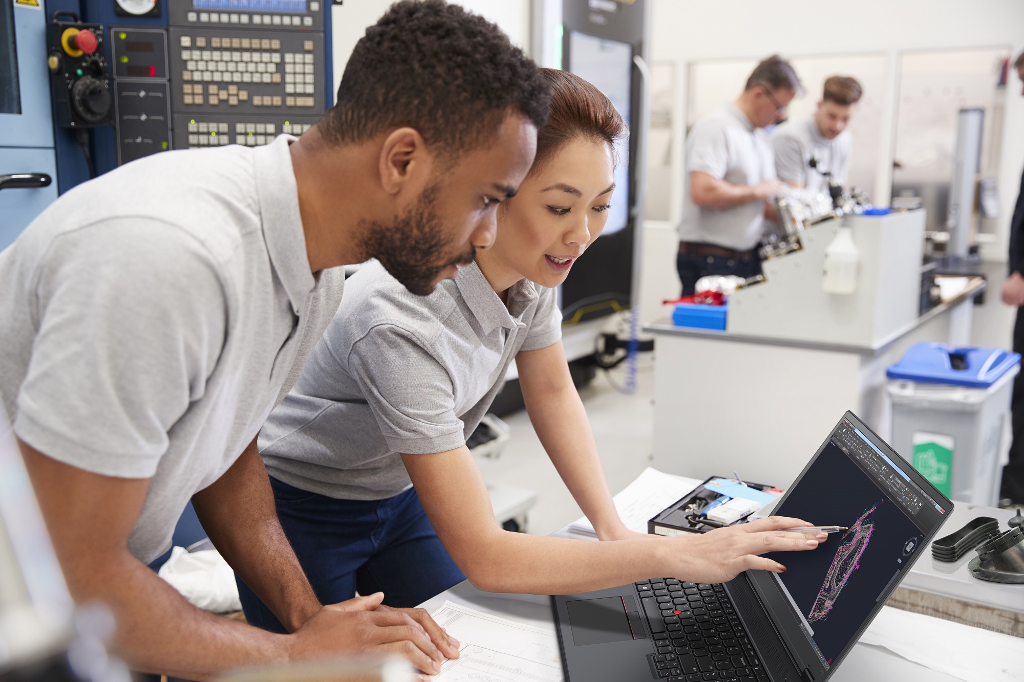 Two people looking at a laptop, with the woman touching it with her hand