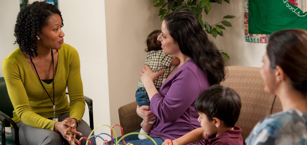 woman with baby talking with counselor